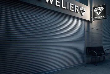 A jeweller’s shop with a fabric-screen roller shutter at night